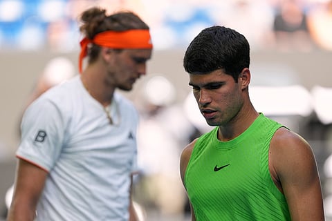 Carlos Alcaraz, right, of Spain walks past Alexander Zverev of Germany during their semifinal match at the Australian Open tennis championship in Melbourne, Australia.
