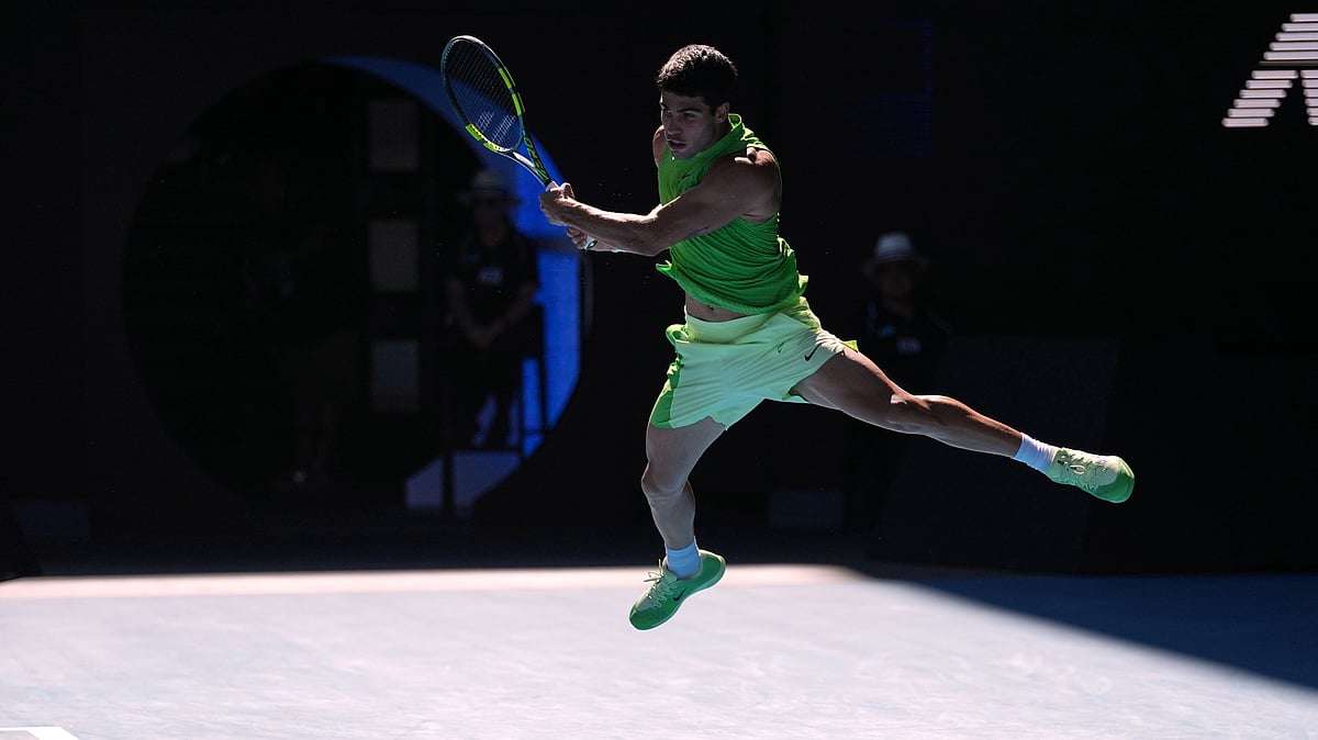 (AP Photo/Dita Alangkara) : Carlos Alcaraz of Spain plays a backhand return to Alexander Zverev of Germany during their semifinal match at the Australian Open tennis championship in Melbourne, Australia, Friday, Jan. 30, 2026. 