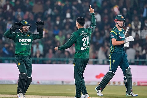 Pakistan's Mohammad Nawaz, center, celebrates with teammate after the dismissal of Australia's Cameron Green, right, during the first T20 cricket match between Pakistan and Australia, in Lahore, Pakistan.