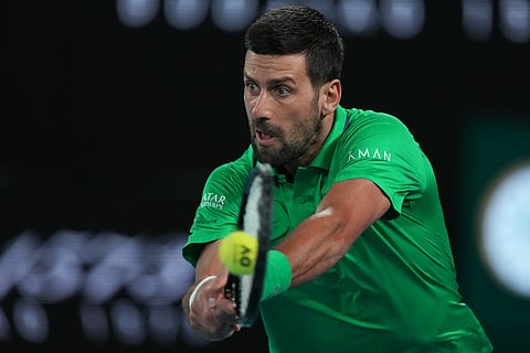 Novak Djokovic of Serbia plays a backhand return to Jannik Sinner of Italy during their semifinal match at the Australian Open tennis championship in Melbourne, Australia.