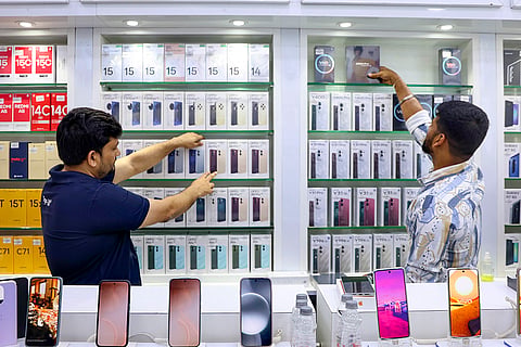 Vendors display mobile phones at a store, ahead of the presentation of the Union Budget 2026-27 by Union Finance Minister Nirmala Sitharaman, in Mumbai.