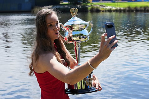 Elena Rybakina of Kazakhstan takes a selfie as she poses with Daphne Akhurst Memorial Cup on the banks of the Yarra River the morning after defeating Aryna Sabalenka of Belarus in the women's singles final at the Australian Open tennis championship in Melbourne, Australia.
