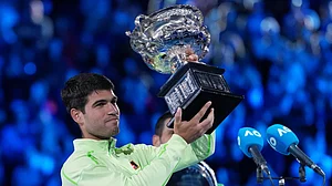 Photo: AP : Carlos Alcaraz of Spain holds the Norman Brookes Challenge Cup after defeating Novak Djokovic of Serbia in the men's singles final at the Australian Open tennis championship in Melbourne.
