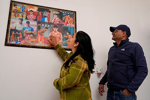 Seema Sharma and Sudesh Kumar, parents of Kashvee Gautam, at their home in Zirakhpur, looking at a poster marking her professional milestones. ‘We are only proud,’ they say. 