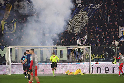 Cremonese's goalkeeper Emil Audero lies on the pitch after fans throw a flair towards him during the Serie A soccer match between Cremonese and Inter in Cremona, Italy.