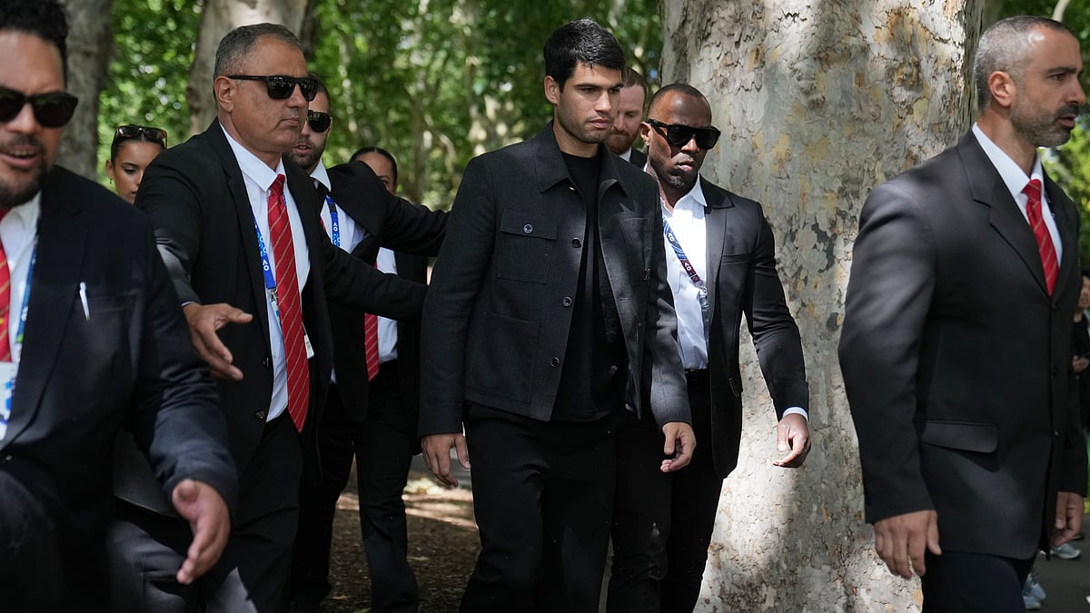 | Photo: AP/Dita Alangkara : Carlos Alcaraz of Spain, center, is escorted by security guards the morning after defeating Novak Djokovic of Serbia in the men's singles final at the Australian Open tennis championship, in Melbourne, Australia, Monday, Feb. 2, 2026.