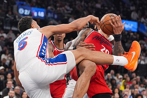 Philadelphia 76ers guard Quentin Grimes (5) descends after he dunked over Los Angeles Clippers forward/center John Collins (20) during the first half of an NBA basketball game in Inglewood, California.