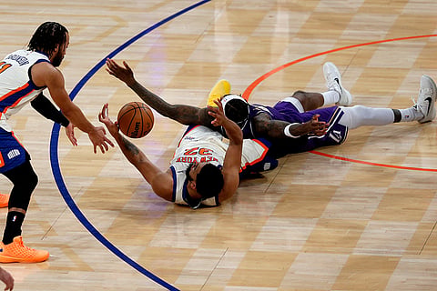 New York Knicks guard Jalen Brunson, left, Knicks center Karl-Anthony Towns, center, and Los Angeles Lakers forward Jarred Vanderbilt, right, go for the ball during the first half of an NBA basketball game in New York.