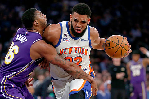 Los Angeles Lakers guard Marcus Smart, left, defends against New York Knicks center Karl-Anthony Towns, right, during the first half of an NBA basketball game in New York.