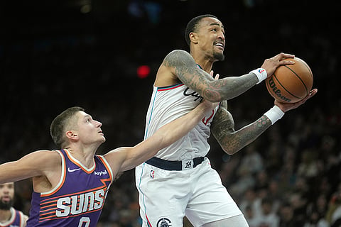 Los Angeles Clippers forward John Collins, right, is fouled by Phoenix Suns guard Grayson Allen, left, during the second half of an NBA basketball game in Phoenix. 