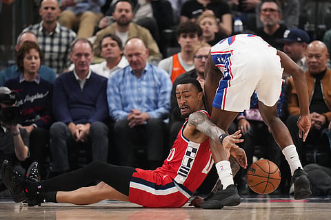 Los Angeles Clippers forward John Collins (20) and Philadelphia 76ers guard Vj Edgecombe (77) scramble for the ball during the first half of an NBA basketball game in Inglewood, California.