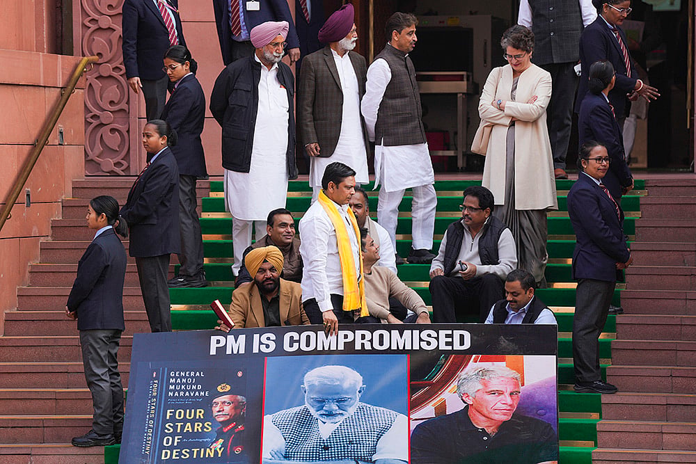 | Photo: PTI/Salman Ali : Congress MP Priyanka Gandhi Vadra with Lok Sabha MPs who were suspended on Tuesday for the remainder of the Budget session for "unruly behaviour'', as they stage a protest with a poster ‘'PM is compromised'’, at Parliament premises in New Delhi.