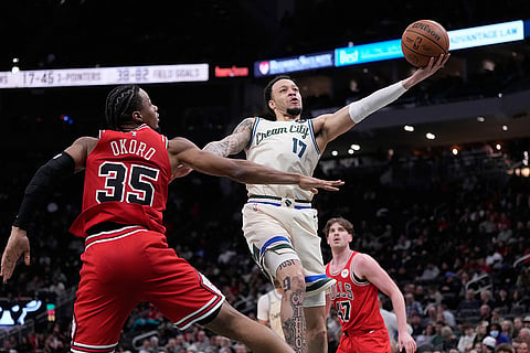 Milwaukee Bucks' Amir Coffey shoots past Chicago Bulls' Isaac Okoro during the second half of an NBA basketball game in Milwaukee. 