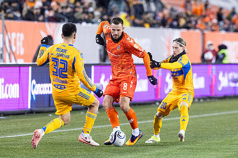 Forge FC's Antoine Batisse (8) passes the ball with pressure from Tigres UANL's Vladimir Lorona (32) and Marcelo Flores (20) during round one of the 2026 CONCACAF Champions Cup in Hamilton.