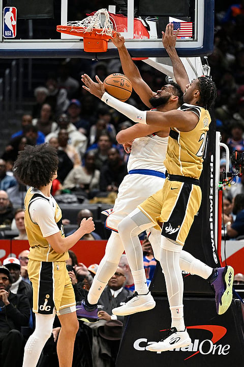 New York Knicks center Karl-Anthony Towns, dunks the ball against Washington Wizards center Alex Sarr, right, during the first half of an NBA basketball game in Washington.