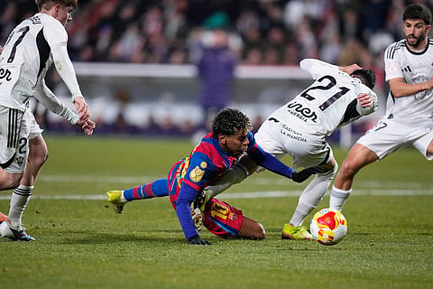 Barcelona's Lamine Yamal fights for the ball against Albacete's Carlos Neva during a Copa del Rey quarterfinal soccer match between Albacete and Barcelona, in Albacete, Spain.