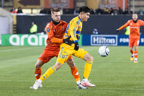 Forge FC's Rezart Rama (24) fights for a ball with Tigres UANL's Vladimir Lorona (32) during round one of the 2026 CONCACAF Champions Cup in Hamilton.