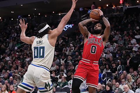 Chicago Bulls' Coby White shoots over Milwaukee Bucks' Jericho Sims during the first half of an NBA basketball game in Milwaukee. 