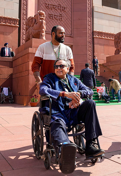 Congress MP Shashi Tharoor in a wheelchair after he tripped and fell on the stairs of Parliament complex on Wednesday during the Budget Session of Parliament, in New Delhi.