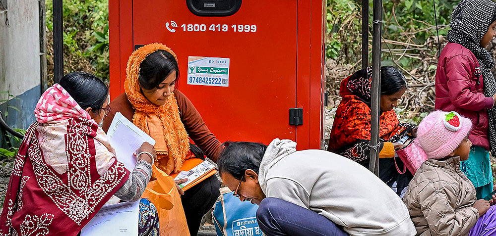 PTI : People arrange their documents during hearings under the Special Intensive Revision (SIR) of electoral rolls.