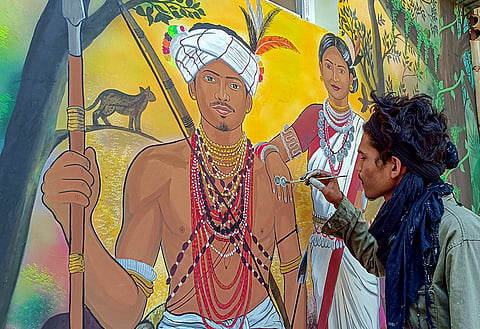 An artist creates a tribal painting on a wall at the ‘Janjatiya Gaurav Vatika’ ahead of its inauguration, in Jagdalpur, Bastar district.