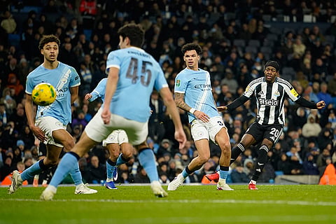 Newcastle's Anthony Elanga, right, scores during the English League Cup semifinal soccer match soccer match between Manchester City and Newcastle in Manchester, England.