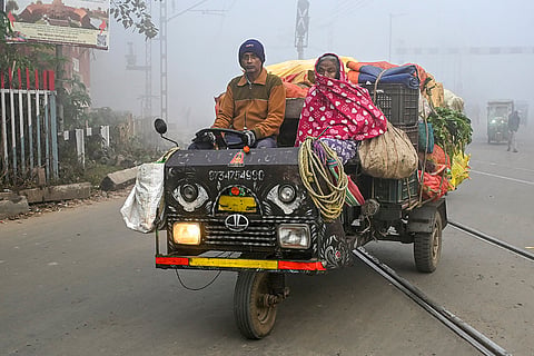 A vendor crosses railway tracks on a foggy winter morning, in Nadia, West Bengal.