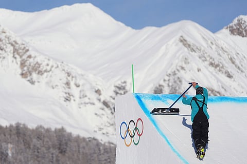 A worker preps a ramp before a freestyle skiing slopestyle training session at the 2026 Winter Olympics, in Livigno, Italy.