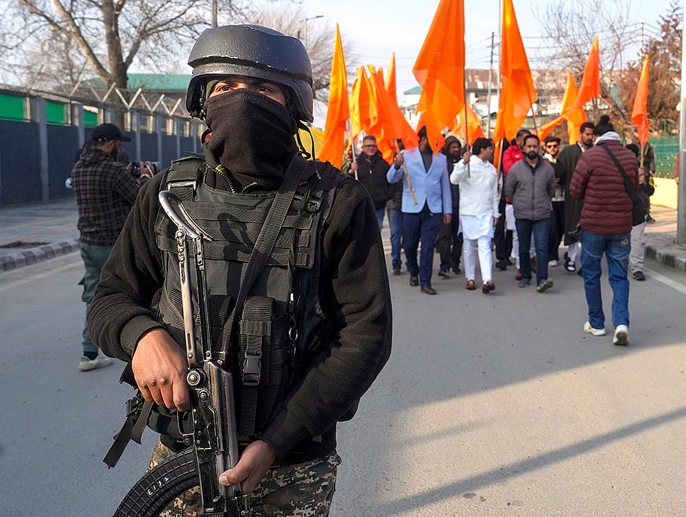 | Photo: PTI/S Irfan : A jawan keeps watch as people participate in a cross-country 'Dhwaj Yatra' organised as part of celebrations of 100 years of Rashtriya Swayamsevak Sangh (RSS), in Srinagar. The rally commenced from historic Lal Chowk on Friday, and is scheduled to culminate in Kanyakumari. 