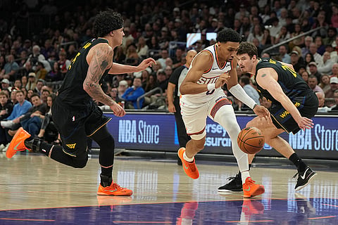 Phoenix Suns forward Ryan Dunn drives past Golden State Warriors forward Gui Santos and center Quinten Post during the first half of an NBA basketball game in Phoenix.