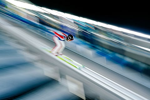 Liu Qi of China goes down the ramp during a ski jumping women's normal hill training session at the 2026 Winter Olympics in Predazzo, Italy.