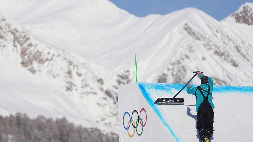 Photo: AP/Lindsey Wasson : A worker preps a ramp before a freestyle skiing slopestyle training session at the 2026 Winter Olympics, in Livigno, Italy.