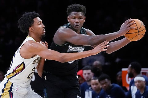 Minnesota Timberwolves guard Anthony Edwards, right, protects the ball from New Orleans Pelicans forward Trey Murphy III (25) in the third quarter of an NBA basketball game in Minneapolis.