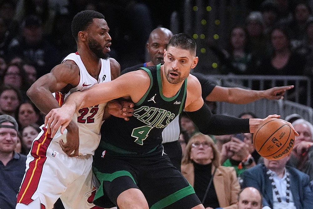 | Photo: AP/Charles Krupa : Miami Heat forward Andrew Wiggins (22) tries to stop Boston Celtics center Nikola Vucevic (4) during the second half of an NBA basketball game in Boston. 
