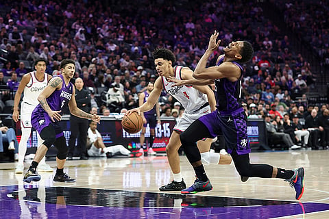 Sacramento Kings forward De'Andre Hunter, right, reacts after getting hit in the eye by Los Angeles Clippers guard Kobe Sanders, center, during the second half of an NBA basketball game in Sacramento, California.