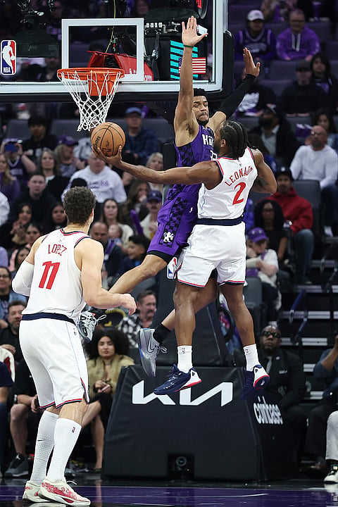 Los Angeles Clippers forward Kawhi Leonard (2) attempts to shoot around Sacramento Kings center Dylan Cardwell, center, during the first half of an NBA basketball game in Sacramento, California.