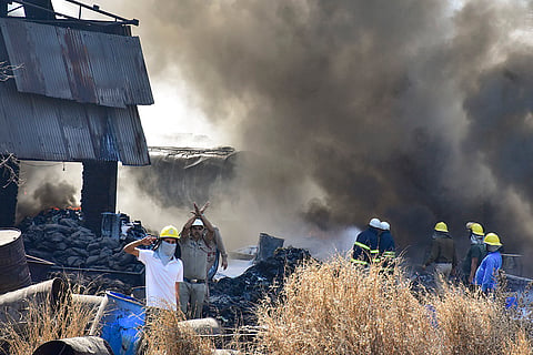 Thick black smoke billows as firefighters battle a blaze at a bitumen and wire factory, in Raipur.