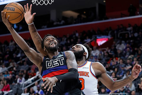 Detroit Pistons forward Paul Reed, left, lays up a shot against New York Knicks center Mitchell Robinson, right, during the second half of an NBA basketball game in Detroit. 