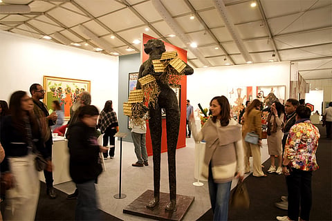 Art enthusiasts examine works at the India Art Fair