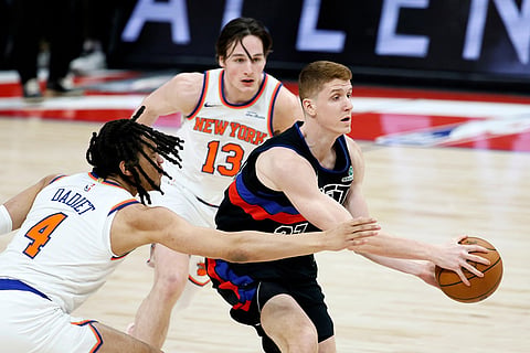 Detroit Pistons guard Kevin Huerter, right, drives to the basket past New York Knicks forward Pacome Dadiet (4) and guard Tyler Kolek (13) during the second half of an NBA basketball game in Detroit. 