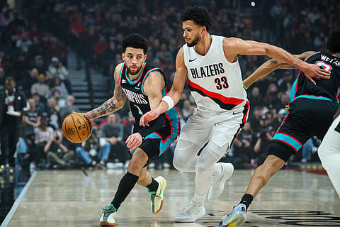 Memphis Grizzlies guard Scotty Pippen Jr. (1) dribbles past Portland Trail Blazers forward Toumani Camara (33) during the first half of an NBA basketball game in Portland, Oregon.