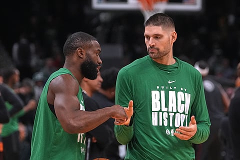 Boston Celtics center Nikola Vucevic, right, shakes hands with guard Jaylen Brown prior to an NBA basketball game against the Miami Heat in Boston. 