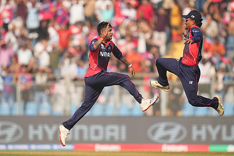 Nepal's Sandeep Lamichhane, left, celebrates the wicket of England's Tom Banton with captain Rohit Paudel during the T20 World Cup cricket match between England and Nepal in Mumbai, India.