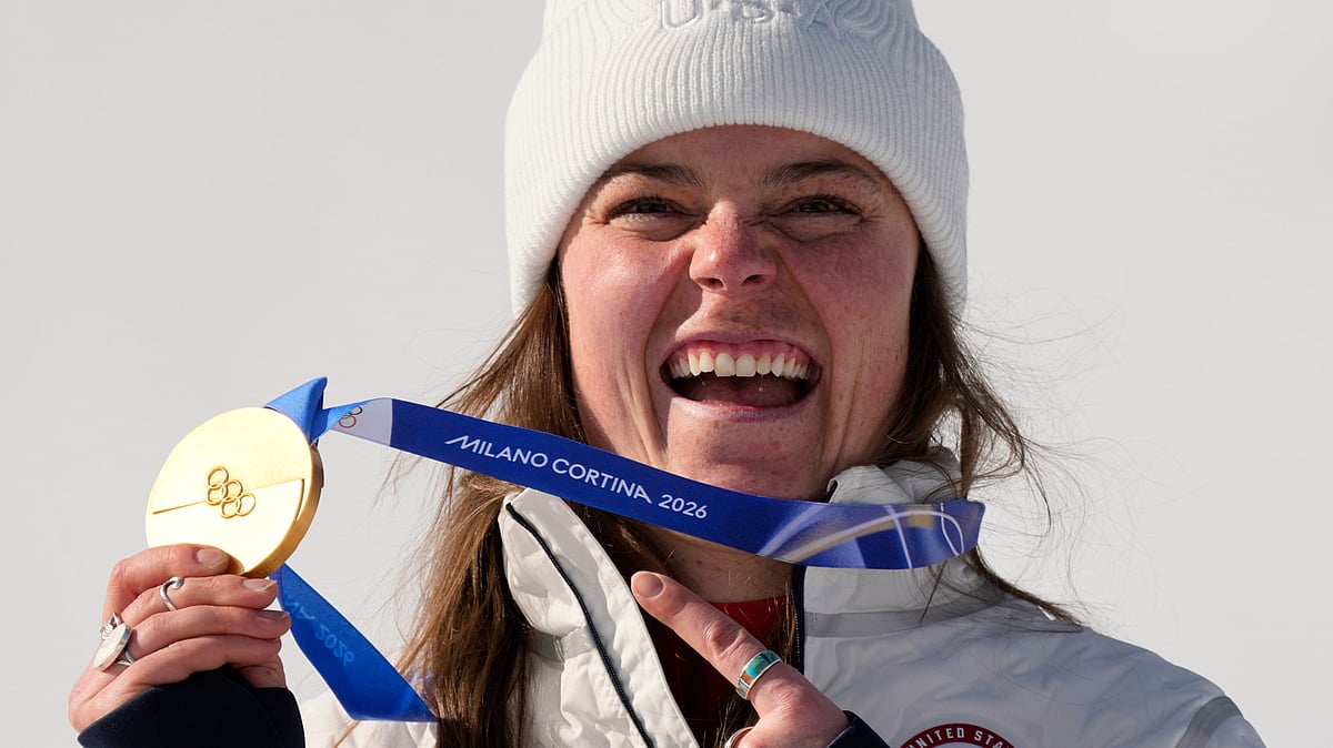 (AP Photo/Andy Wong) : United States' Breezy Johnson shows her gold medal in the alpine ski women's downhill race, at the 2026 Winter Olympics, in Cortina d'Ampezzo, Italy, Sunday, Feb. 8, 2026. 
