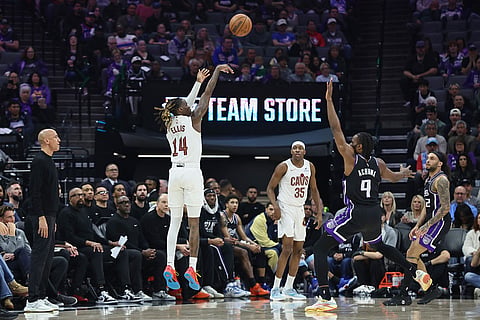Cleveland Cavaliers guard Keon Ellis (14) makes a 3-pointer over Sacramento Kings forward Precious Achiuwa (9) during the first half of an NBA basketball game in Sacramento, Calif.