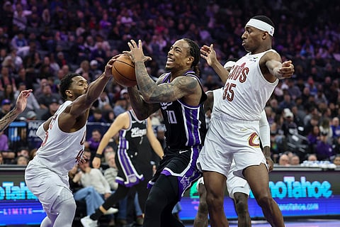 Cleveland Cavaliers guard Donovan Mitchell, left, blocks the ball as Sacramento Kings guard DeMar DeRozan (10) goes up for a layup during the first half of an NBA basketball game in Sacramento, Calif.