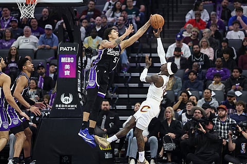 Sacramento Kings guard Nique Clifford (5) blocks Cleveland Cavaliers guard Keon Ellis (14) during the first half of an NBA basketball game in Sacramento, Calif.