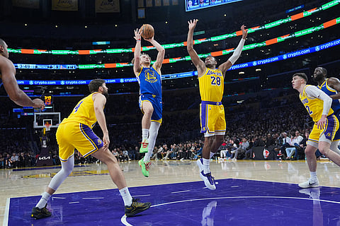 Golden State Warriors guard Brandin Podziemski (2) goes up for basket under defense by Los Angeles Lakers forward Rui Hachimura (28) during the first half of an NBA basketball game in Los Angeles.