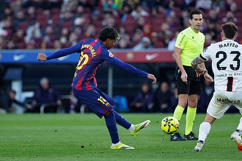 Barcelona's Lamine Yamal, left, scores his side's 2nd goal during the Spanish La Liga soccer match between Barcelona and Mallorca in Barcelona, Spain.