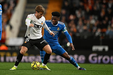 Valencia's Lucas Beltran, left, and Real Madrid's Aurelien Tchouameni challenge for the ball during the Spanish La Liga soccer match between Valencia and Real Madrid in Valencia, Spain.